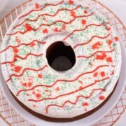 Delicious festive cake with white icing, red and green sprinkles, and decorative red icing. Perfect for holidays.