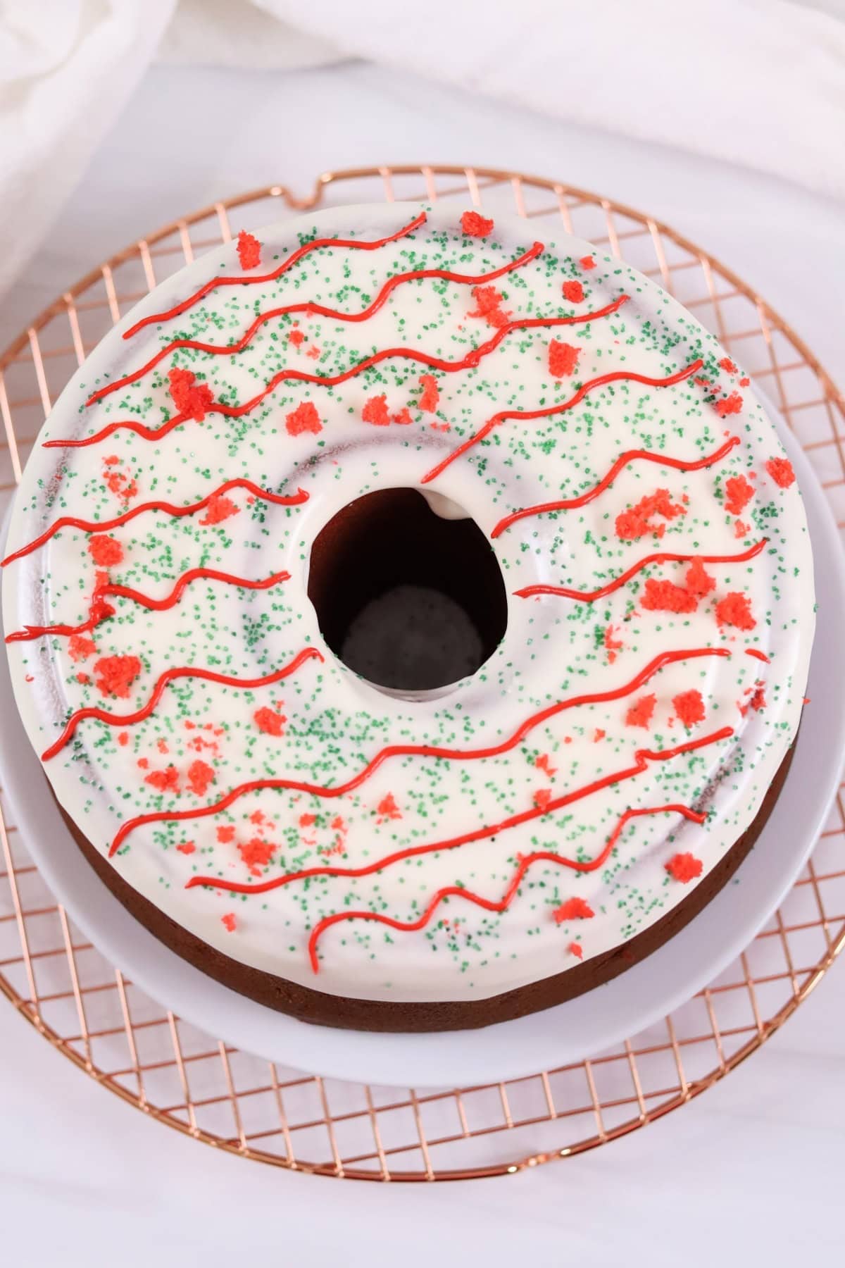 Delicious festive cake with white icing, red and green sprinkles, and decorative red icing. Perfect for holidays.